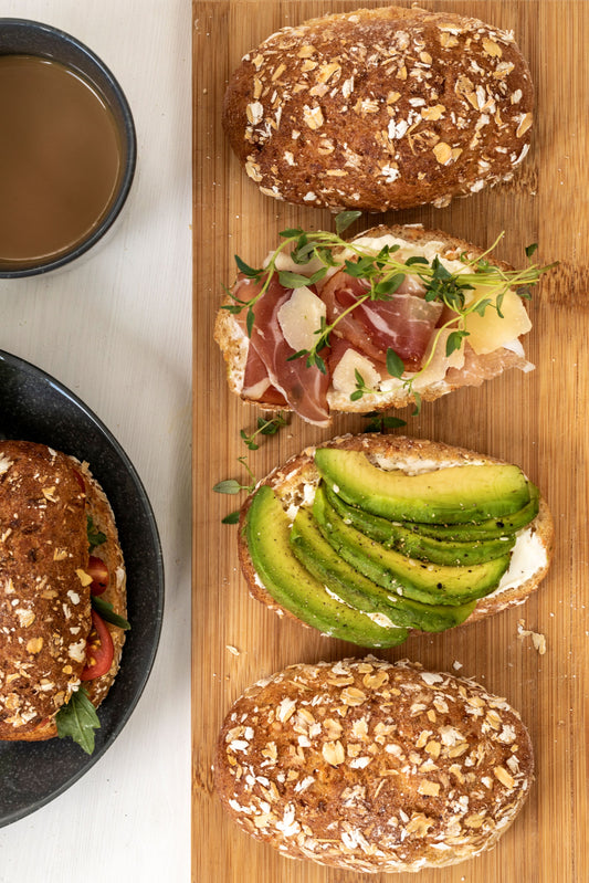 Halverad glutenfri havrefralla med avokado och kaffekopp i bakgrunden